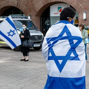Ein Mann hat sich bei einer Demonstration in Hamburg in eine israelische Fahne gehüllt (Archivbild).