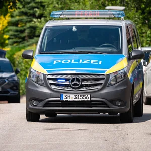 Fahrzeuge der Polizei und der Spurensicherung stehen in der Nähe eines Tatorts. (Symbolbild)