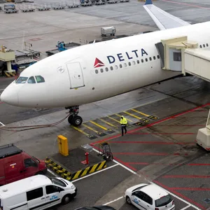 Ein Flugzeug von Delta Airlines steht mit angedockter Gangway auf einem Flughafen