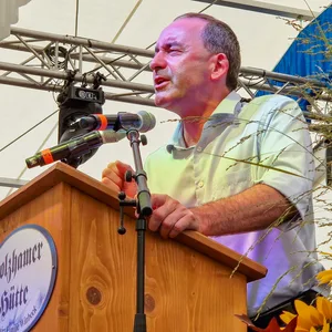 Bayerns Vize-Ministerpräsident spricht auf dem Karpfhamer Fest zu Besuchern.