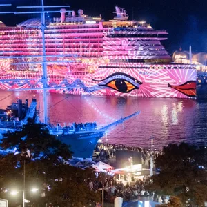 Das Kreuzfahrtschiff AIDAprima wird im Rahmen einer Kunstaktion des Lichtkünstlers Michael Batz bei den Cruise Days 2022 mit farbigem Licht und Mustern angestrahlt.