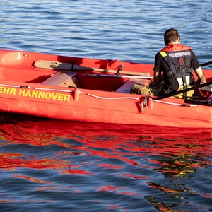 Ein Feuerwehrmann ist im Licht der Abendsonne mit einem Schlauchboot auf dem Mittellandkanal in Hannover-Vinnhorst unterwegs.