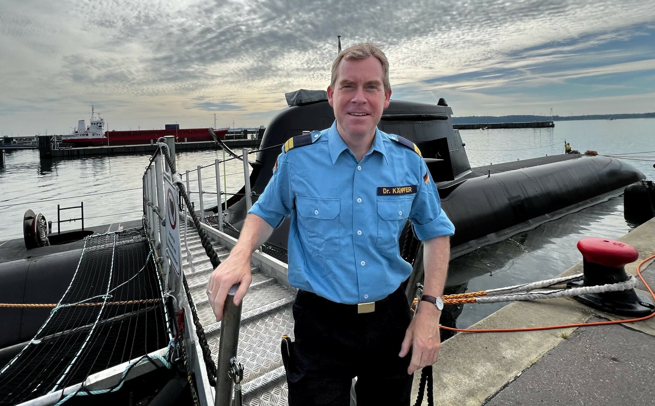 Kiels Oberbürgermeister Ulf Kämpfer posiert vor einem U-Boot.