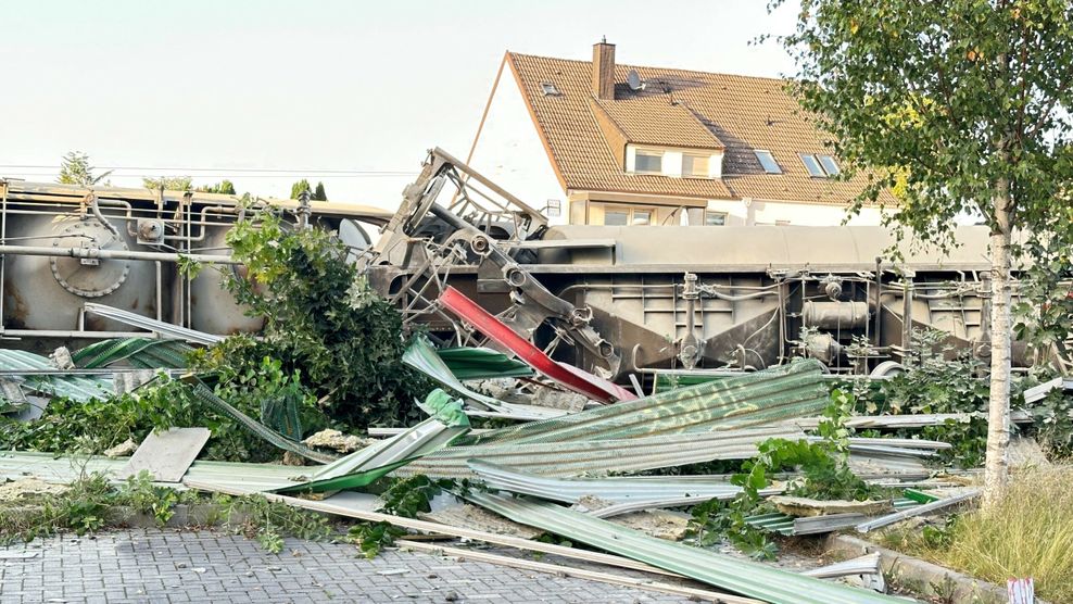 Teile eines entgleisten Güterzuges sind an der Bahnstrecke zu sehen.