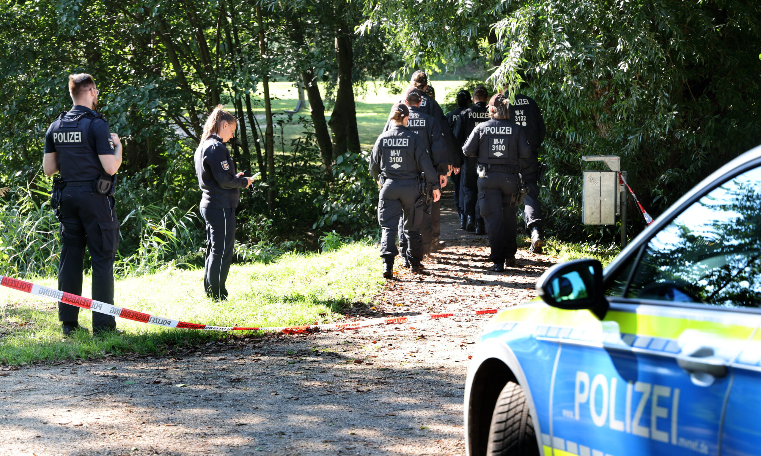 Polizeikräfte gehen zum abgesperrten Fundort am Haussees, wo am Donnerstagabend der schwer verletzte Sechsjährige gefunden wurde, der später an seinen Verletzungen verstarb.