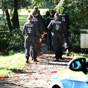 Polizeikräfte gehen zum abgesperrten Fundort am Haussees, wo am Donnerstagabend der schwer verletzte Sechsjährige gefunden wurde, der später an seinen Verletzungen verstarb.