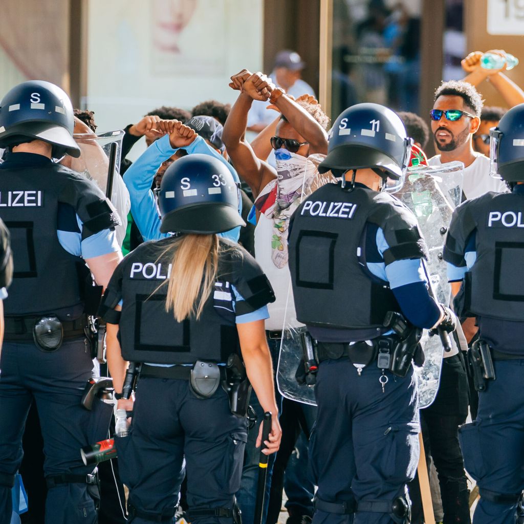 Eine Gruppe von Menschen wird nach Ausschreitungen bei einer Eritrea-Veranstaltung von Polizeikräften eingekesselt.