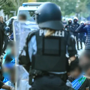 Eine Gruppe von Menschen wird nach Ausschreitungen bei einer Eritrea-Veranstaltung von Polizeikräften eingekesselt.
