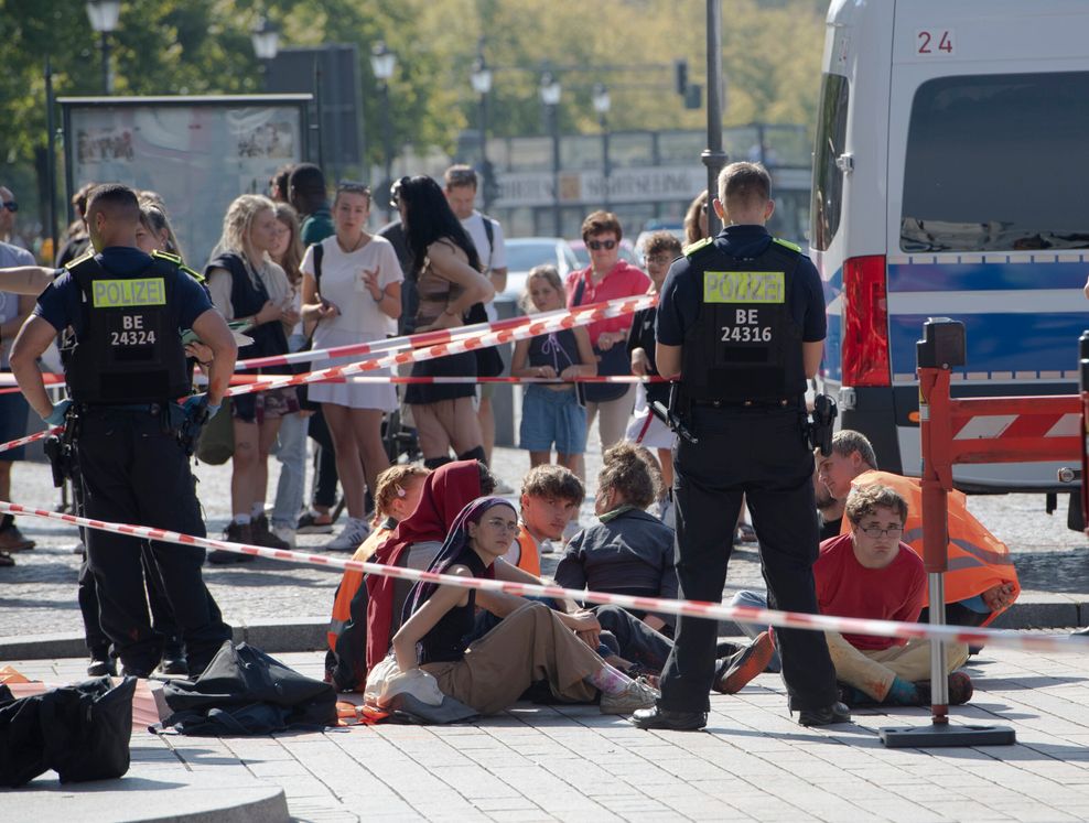 Polizeibeamte stehen am Brandenburger Tor um eine Gruppe festgesetzter