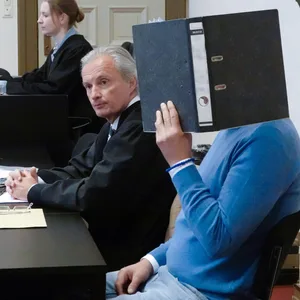 Der 48-jährige Angeklagte (r.), sein Rechtsanwalt Rolf Huschbeck (2.v.r) und eine weitere Prozessbeteiligte sitzen zu Beginn des Prozesses im Gerichtssaal.