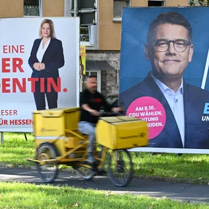 Wahlplakate der Spitzenkandidaten Boris Rhein (CDU, r), Ministerpräsident von Hessen, und Nancy Faeser (SPD), Bundesinnenministerin, stehen an einer Straße.