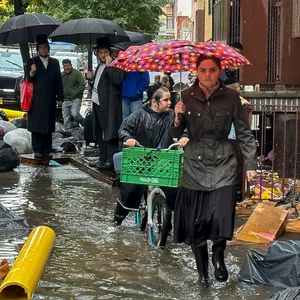 Fußgänger gehen im Stadtteil Brooklyn über einen überfluteten Bürgersteig.