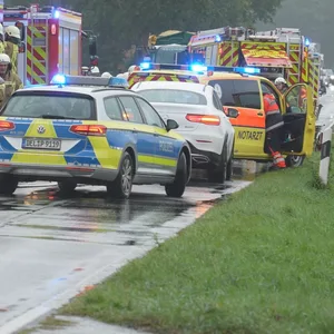 Helfer stehen nach dem Unfall auf der Landstraße bei Wildeshausen.