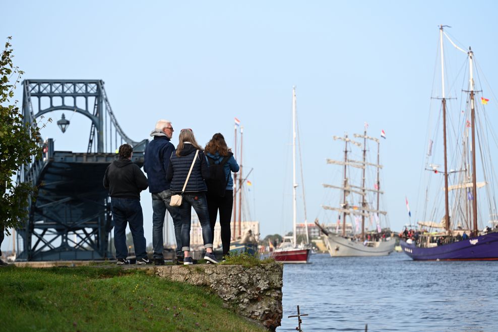 Zuschauer verfolgen das Auslaufen der Segelschiffe in Wilhelmshaven.