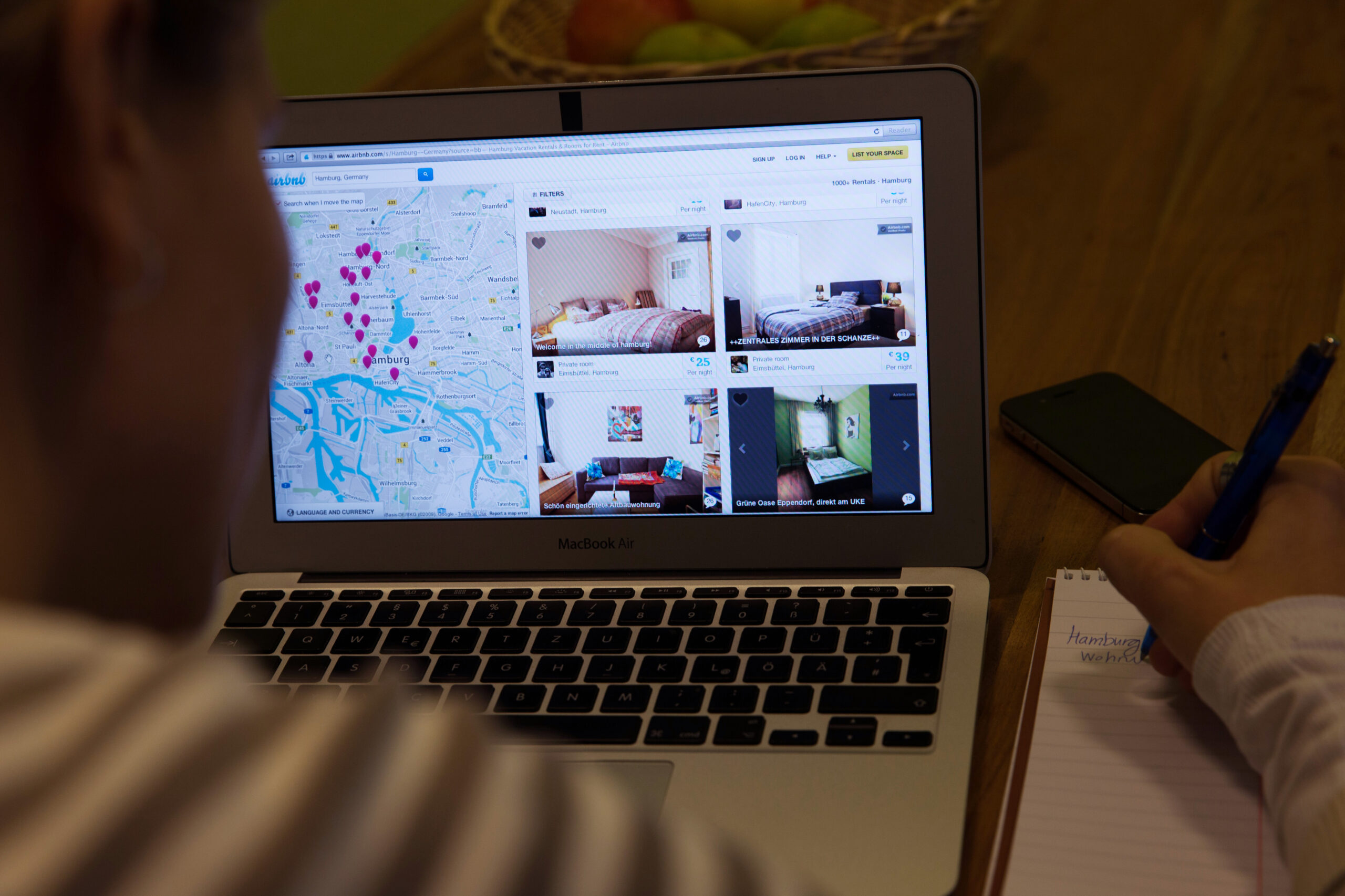 Ein User sitzt am Laptop, zu sehen ist eine Seite des Portals „Airbnb“.