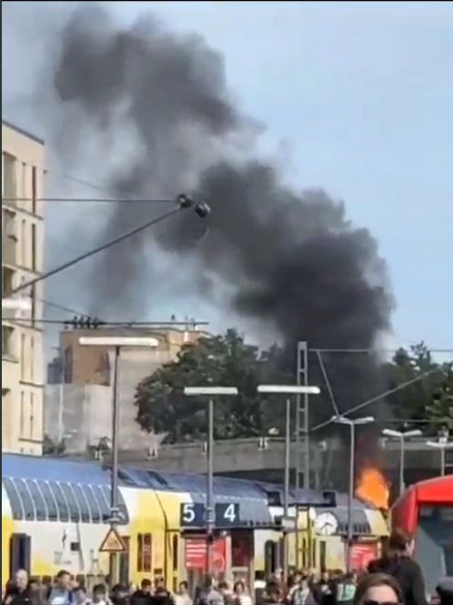 Der Zug steht im Bahnhof, eine schwarze Rauchwolke steigt auf.