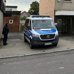 Mannschaftswagen der Polizei vor der Einfahrt zur Moschee in Neumünster.