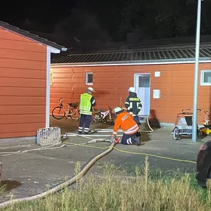 Die Einsatzkräfte vor dem Wohncontainer in Sittensen.