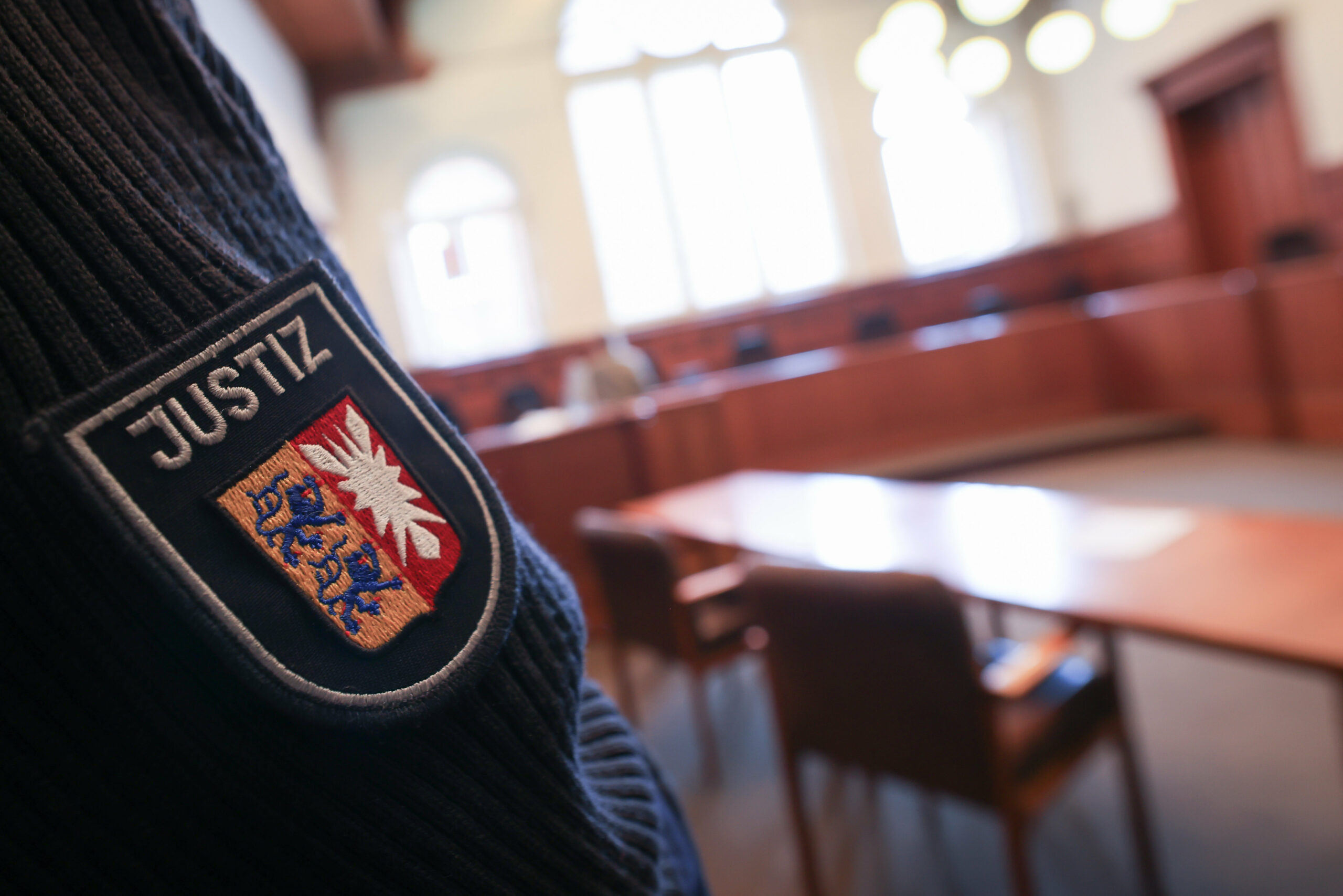 Ein Justizbeamter steht im Gerichssaal im Landgericht Flensburg.