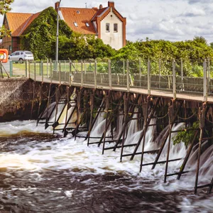 Das Wittorfer Nadelwehr der Ilmenau. Im Hintergrund das Schleusenwärterhaus aus dem Jahr 1893