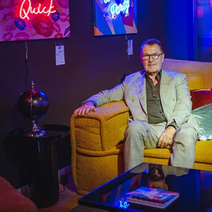 Eck sitzt auf einem Sofa, um ihn herum Wohnaccessoires