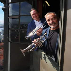 Die Turmbläser Horst Huhn (r.) und Josef Thöne schauen aus einem Fenster im Turm der Hauptkirche St. Michaelis.