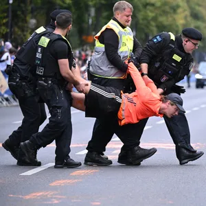 Polizisten tragen einen Aktivisten der Letzten Generation weg.
