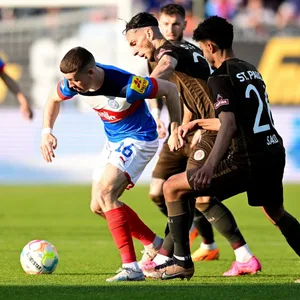 Elias Saad und Leart Paqarada im Duell mit Kiels Philipp Sander
