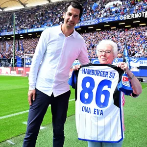 HSV-Sportvorstand Jonas Boldt überreicht Oma Eva ein Trikot
