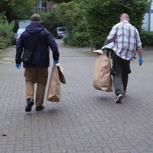 Ermittler tragen mögliche Beweismittel aus einer Wohnung in Heimfeld.