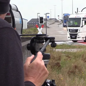 Ein Polizist misst die Geschwindigkeit eines abbiegenden Lkw.