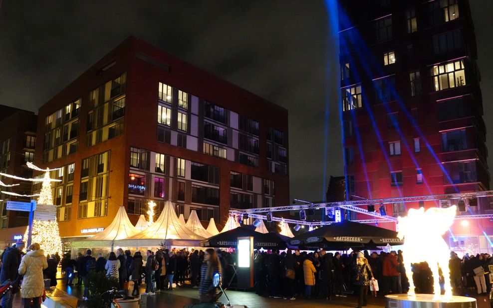 Besucher gehen über den Weihnachtsmarkt im Überseequartier in der Hafencity.