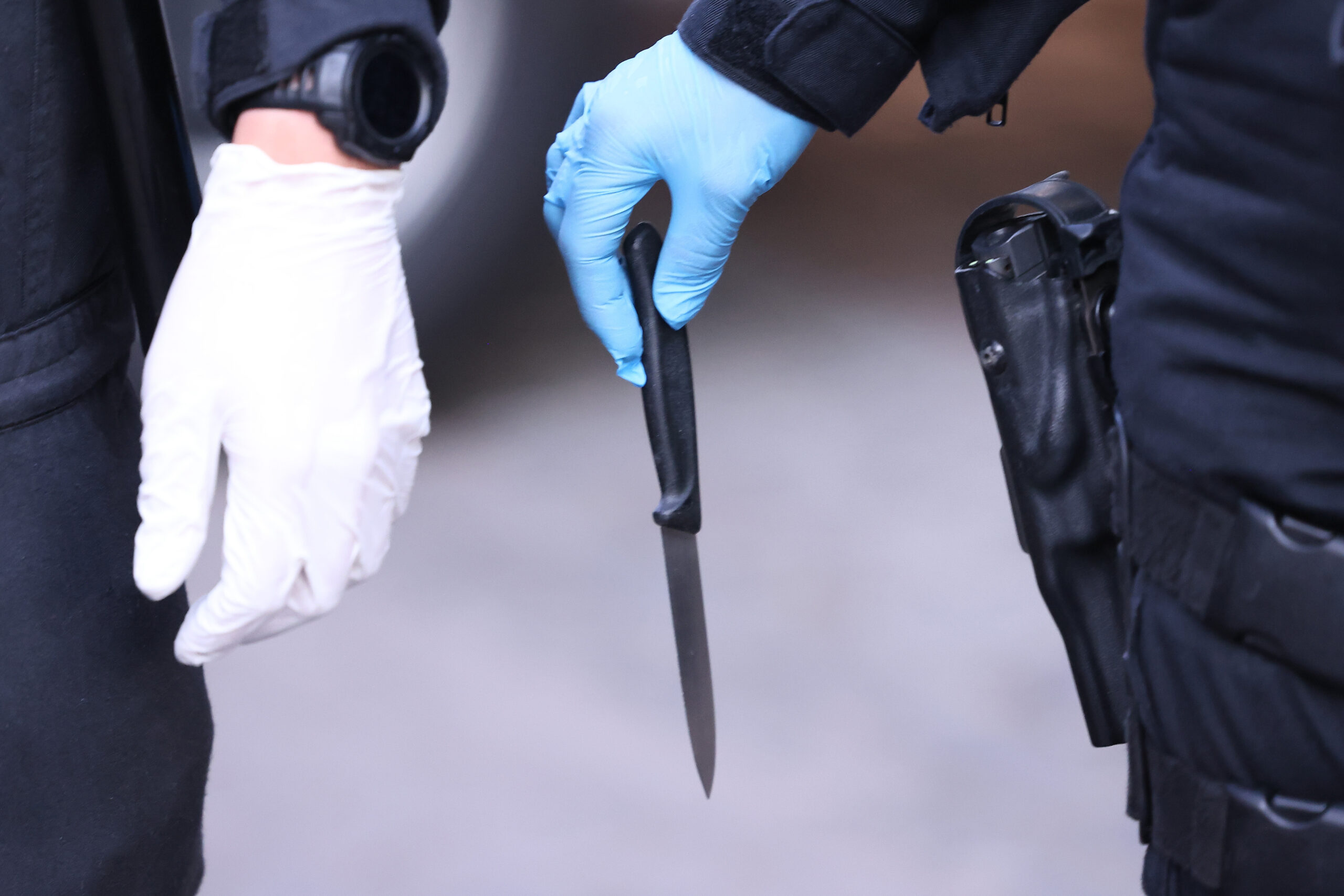 Ein Polizist hält ein sichergestelltes Messer in der Hand.