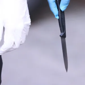 Ein Polizist hält ein sichergestelltes Messer in der Hand.