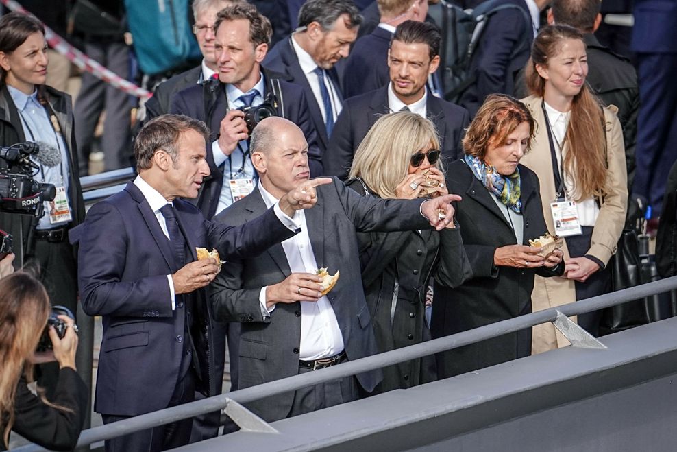 Frankreichs Präsident Emmanuel Macron (l-r), Bundeskanzler Olaf Scholz (SPD) Brigitte Macron und Britta Ernst essen gemeinsam im Treppenviertel in Blankenese an der Elbe ein Fischbrötchen.