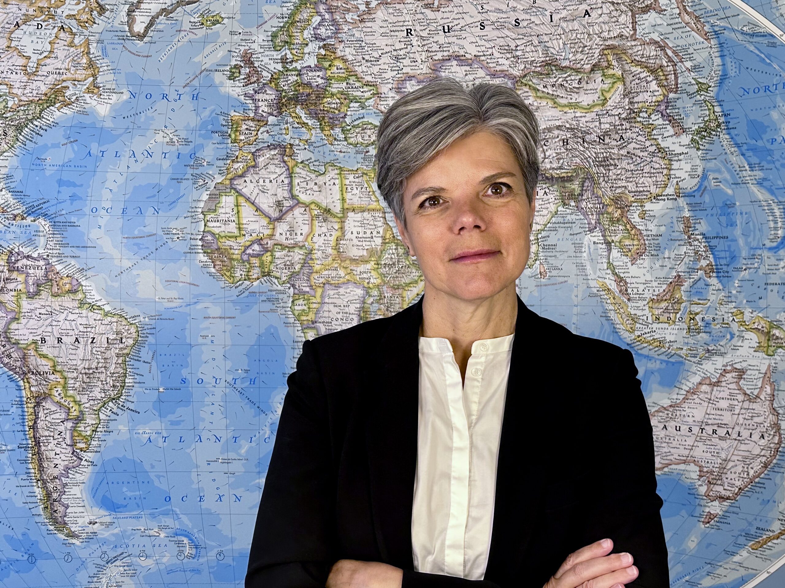 Die Generalsekretärin des Dänischen Flüchtlingsrates (DRC), Charlotte Slente, vor einer Weltkarte