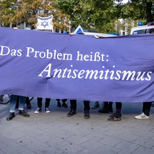 Pro-israelische Demonstranten halten ein Transparent mit der Aufschrift „Das Problem heißt Antisemitismus“ hoch.