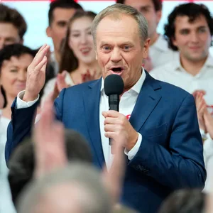Tusk Polen spricht in ein Mikrofon, rund um ihn herum Anhängerinnen und Anhänger