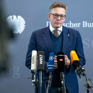 Konstantin von Notz (Grüne) steht im Bundestag vor den Mikros mehrerer Sender