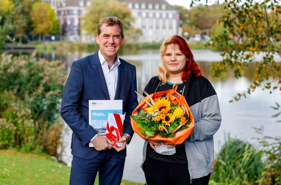 Kiels Oberbürgermeister Ulf Kämpfer (SPD) begrüßt die 18-jährige Kimberly Jones als 250.000. Kieler Bürgerin.