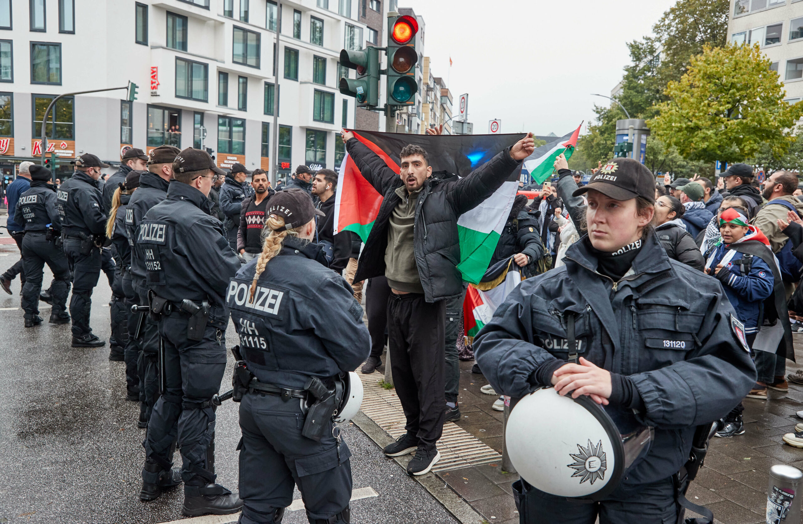 Demonstranten mit Palästina-Flaggen stehen am Samstag vor Polizisten auf dem Steindamm in St Georg. Die Demonstration war zuvor verboten worden.