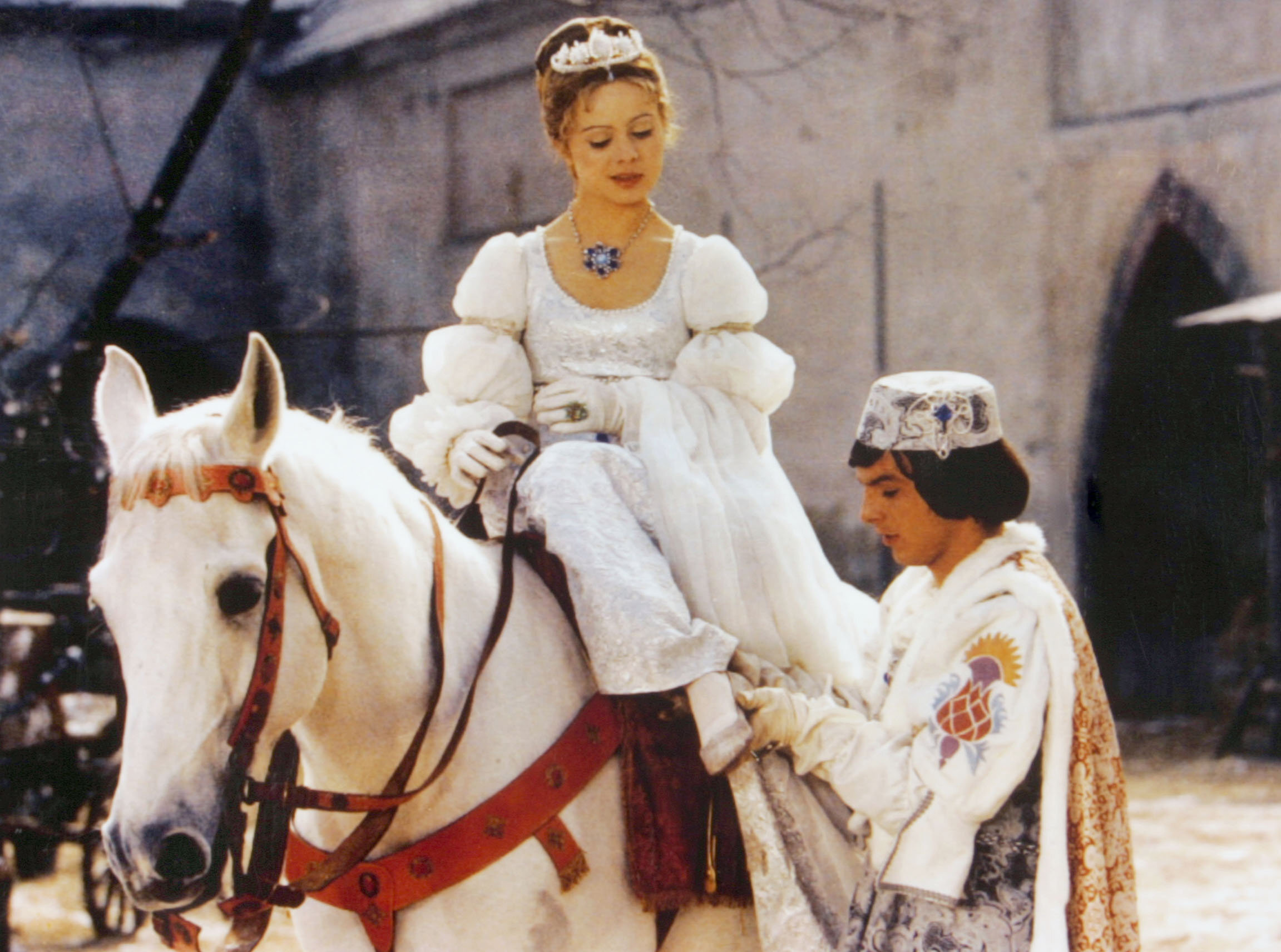 Der Prinz (Pavel Trávnícek) passt Aschenbrödel (Libuse Safránková) den verlorenen Schuh an - eine Szene aus „Drei Haselnüsse für Aschenbrödel“.