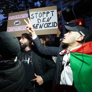 Teilnehmer halten pro-palästinensische Plakate und Flaggen während einer Kundgebung der Schura hoch.