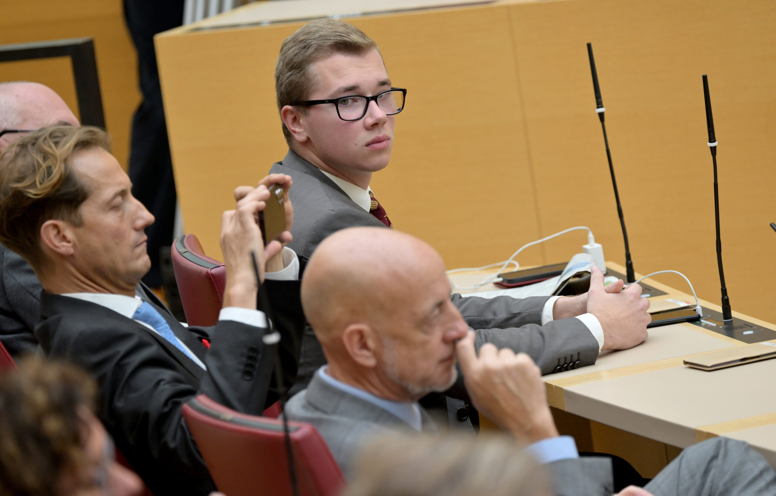 Daniel Halemba (M, AfD) sitzt, nach seiner gestrigen Verhaftung, wieder in der Plenarsitzung des Bayerischen Landtags.