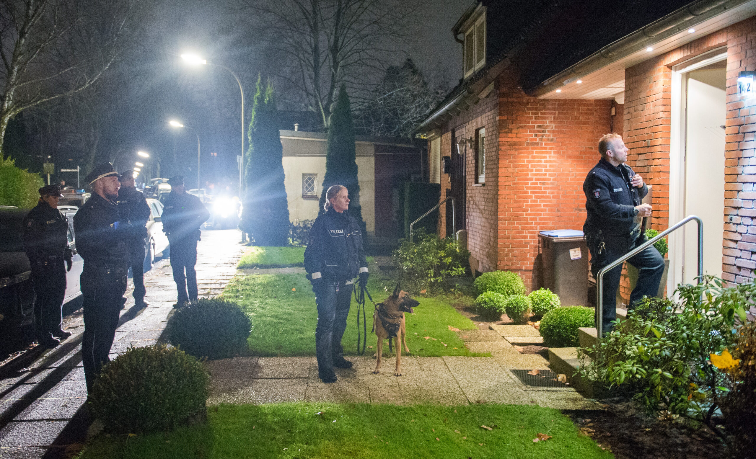 Hamburger Polizeikräfte durchsuchen die Umgebung eines Wohnhauses nach einem Einbruchsversuch (Archivbild).