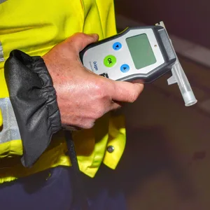 Polizist mit einem Alkohol-Testgerät (Symbolbild).