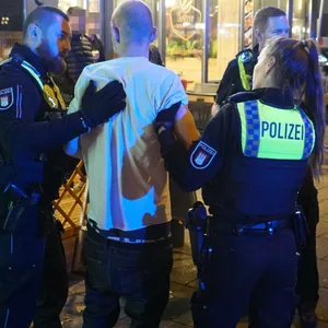 Polizisten führen den mutmaßlichen Täter ab.