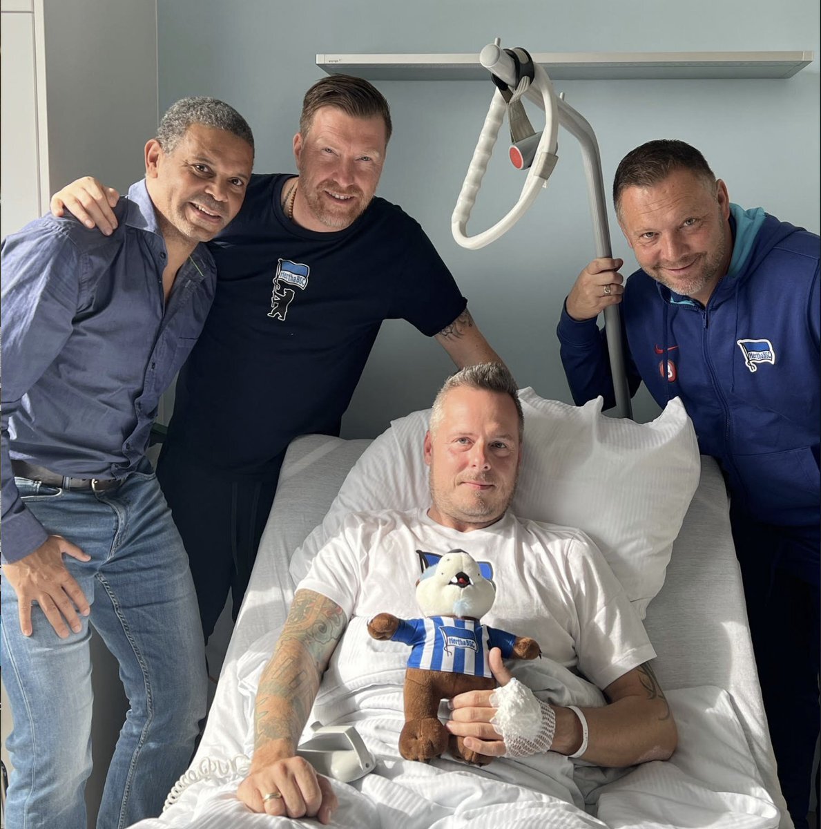 Drei Männer und ein Bär: Hertha-Boss Frank Bernstein ist im Krankenhaus nicht allein.