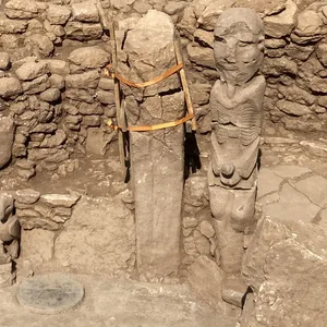 Eine 10.000 Jahre alte Statue eines Mannes, der mit beiden Händen einen Phallus hält.