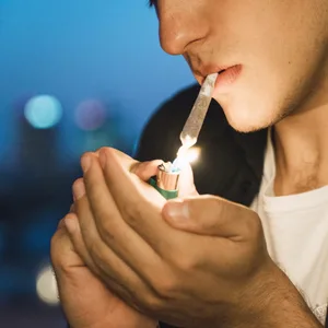 Ein Mann zündet sich einen Joint an